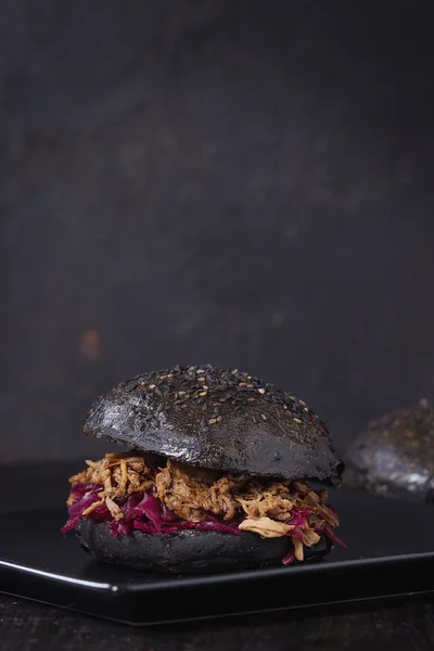 Hambúrguer preto com ensopados — Fotografia de Stock