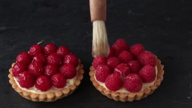 Bitmemiş ve muhallebi ve taze olgun Ahududu ve gri arka plan üzerinde cam için fırça ile tartlets yemeye hazır