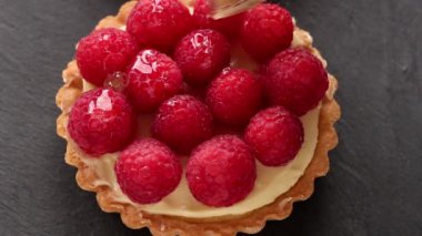 Tartı ile muhallebi ve taze olgun Ahududu ve gri arka plan üzerinde cam için fırça yemeye yarım kalmış. Düz yatıyordu