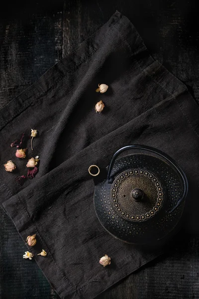 Schwarze Teekanne mit trockenen Rosen — Stockfoto