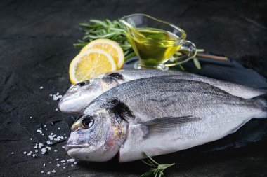 Raw bream fish with herbs clipart