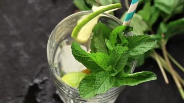 Cam Iced Yeşil çay ile limon, limon ve nane siyah dokulu arka plan üzerine dökülen