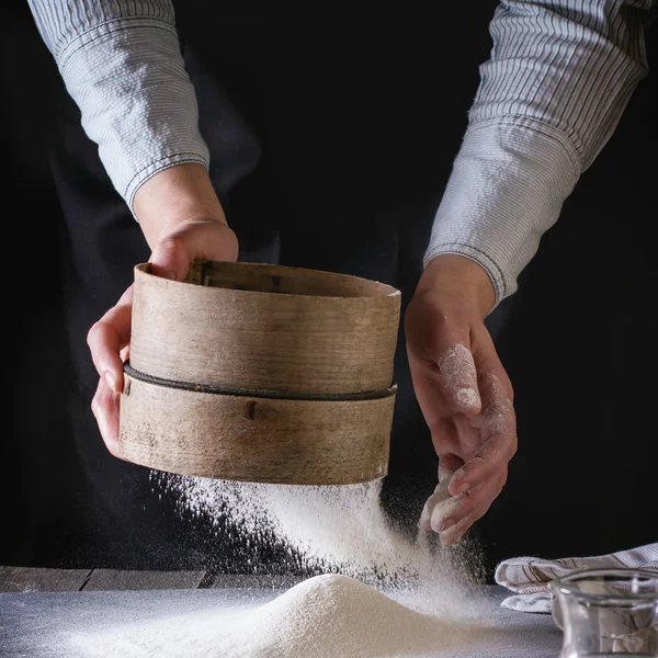 Sifting flour by female hands