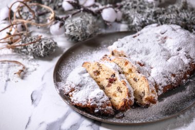 Geleneksel ev yapımı Alman Noel 'i, beyaz mermer arka planda gümüş kostüm süslemeleri ve tabakta çalınmış kek ekmeği pişiriyor..