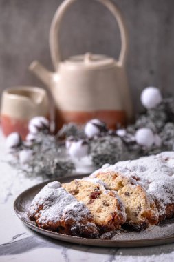 Geleneksel ev yapımı Alman Noel 'i, beyaz mermer arka planda gümüş kostüm süslemeleri ve tabakta çalınmış kek ekmeği pişiriyor..