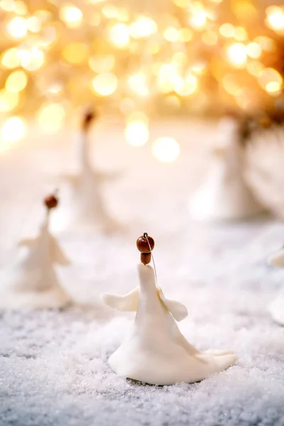 磁器クリスマス天使 雪の上で手作りのクリスマスの装飾のセットボケ休日のライトの背景 — ストック写真