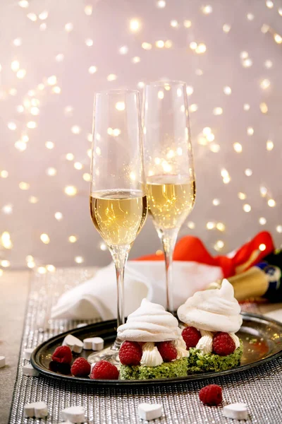二つのシャンパングラスとベリーメレンゲのデザートと聖バレンタインのお祝いのテーブルの設定銀輝くテーブルの上に立つトレイ 白い心 ボケライト — ストック写真