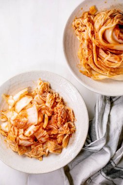 Ev yapımı Kore geleneksel mayalı iştah açıcı kimchi lahana bütün ve beyaz mermer zemin üzerinde seramik tabakta servis edilir. Düz uzanış, boşluk