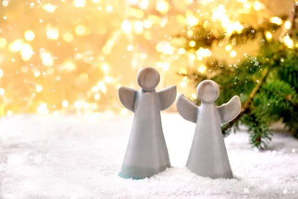 陶瓷圣诞天使 一套两个手工制作的圣诞装饰天使在雪地上 用假灯和冷杉树枝装饰 — 图库照片