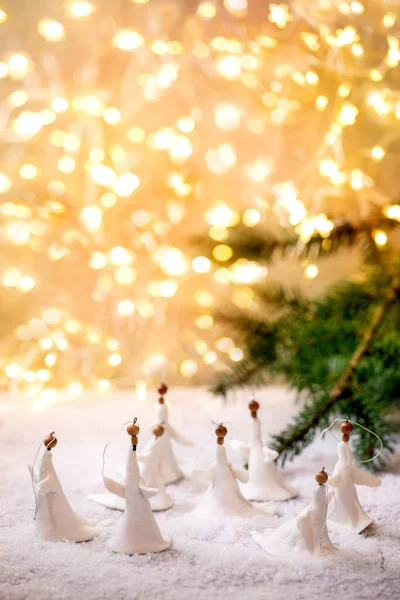 磁器クリスマス天使 ボケの休日のライトとモミの木の枝と雪の上に手作りのクリスマスの装飾のセット — ストック写真