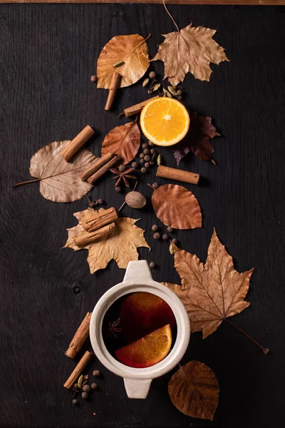 Glühwein Keramiktopf Mit Gewürzen Orangen Und Herbstblättern Über Schwarzem Holzgrund — Stockfoto