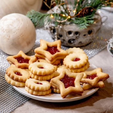 Ev yapımı geleneksel Noel Linz kurabiyeleri ve kırmızı reçelli kurabiyeler. Keten masa örtüsü üzerine ahşap çevre dostu xmas dekorasyonları. Tatil masası. Kare resim