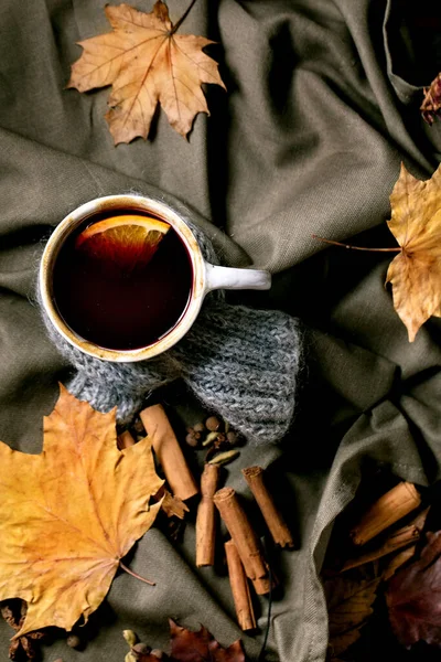 用陶瓷杯盛装热葡萄酒 围巾上有香料 橙色和秋季的叶子覆盖在深色亚麻布桌布上 平躺在床上舒适温暖的酒精饮料 平躺在床上 — 图库照片