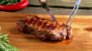 Bir kesme tahtası üzerinde ızgara biftek Dilimleme
