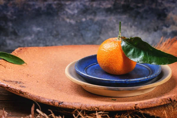 Мандарин на голубой тарелке — стоковое фото