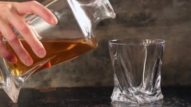 Cam şişe viski gri arka plan üzerinde dökme