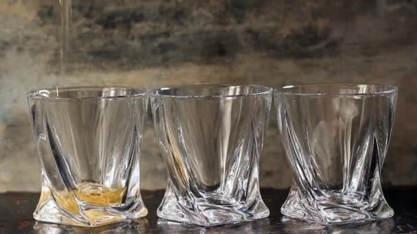 Gieten van whisky in drie glazen — Stockvideo