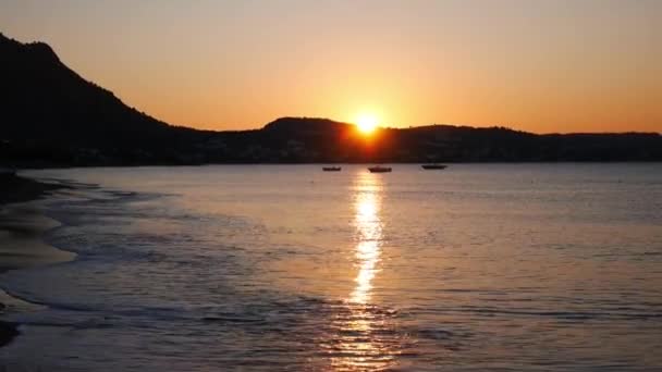 Nascer do sol na praia do mar Mediterrâneo com três barcos — Vídeo de Stock