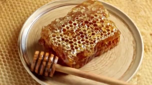Placa cerámica giratoria con panal y tarro de miel de madera — Vídeo de stock
