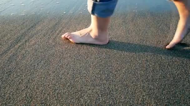 Patas de mujer dejando huella en la arena borrando ola — Vídeo de stock