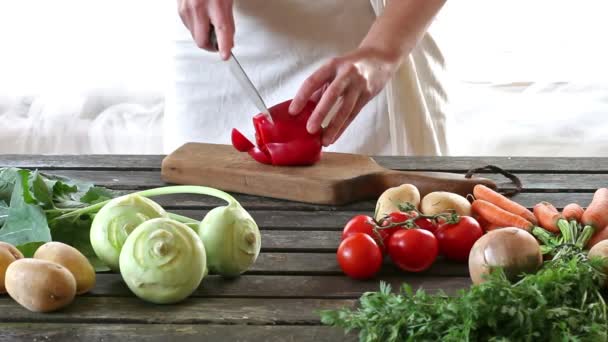Woman slice vegetables. Woman slice paprika on wooden table. Rustic style. — Stock Video