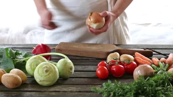 Woman slice vegetables. Woman slice onion on wooden table. Rustic style. — Stock Video