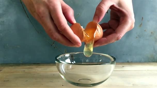Breaking eggs in a glass bowl, slow motion — Stock Video