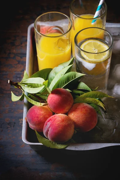 Peaches on branch and juice — Stock Photo, Image