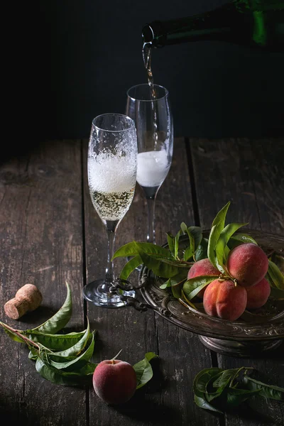 Персики на ветке с шампанским — стоковое фото