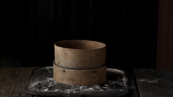 Sieving whole wheat flour through old sieve by woman's hands. Dark rustic style — Stock Video