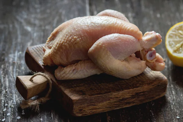 Rå kyckling på trä skärbräda — Stockfoto