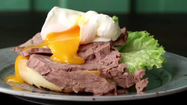 Плямиста тарілка з домашнім бутербродом з запеченим м'ясом та м'яко звареним яєчним рідким жовтком, салат зі шпинату — стокове відео