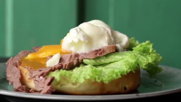 Assiette tachetée rotative avec sandwich maison à la viande cuite au four et jaune d'oeuf à la coque molle, salade d'épinards — Video