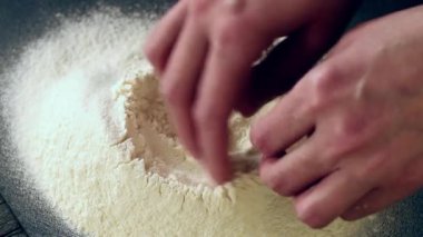 Eller un hamur siyah masa üzerinde yapmak için içine yumurta kırmak