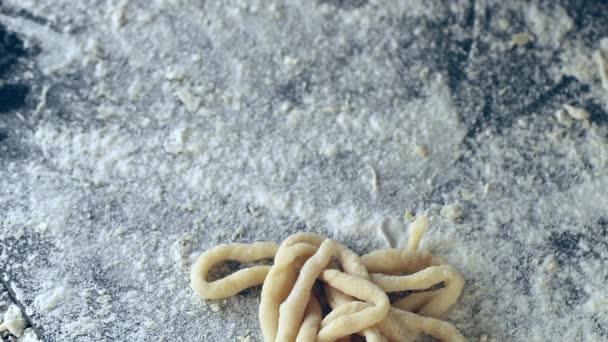 Kvinnliga händer lägga ut pasta pici över svart bord, pudring av mjöl — Stockvideo