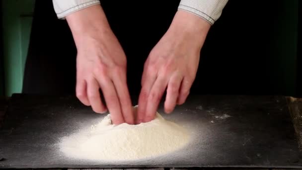 Kobiece ręce break jaj na mąkę do robienia ciasta na stół czarny — Wideo stockowe
