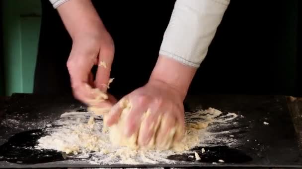 Mãos femininas fazendo massa para massas sobre mesa preta — Vídeo de Stock