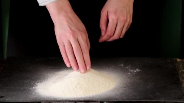 Female hands making dough for pasta over black table — Stock Video