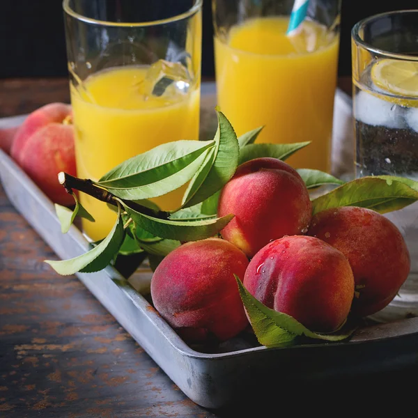 Peaches on branch and juice — Stock Photo, Image