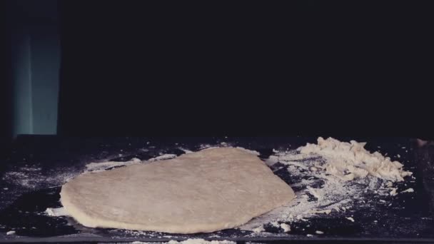 Female hands making dough for pasta over black table. Dark rustic style. In retro filter effect — Stock Video