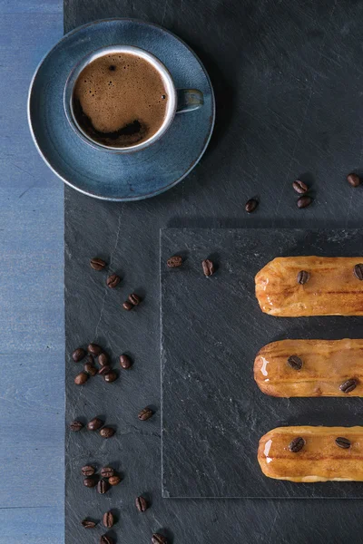 Coffe eclairs with cup of coffee — Stock Photo, Image