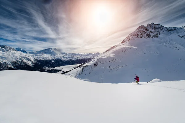 Skiër skiën afdaling in hoge bergen tegen zonsondergang — Stockfoto