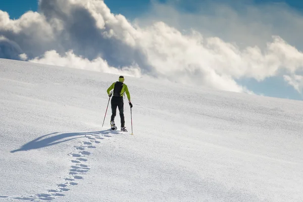 Uomo con le ciaspole sulla neve — Foto Stock