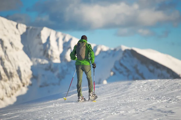 Montañista en paisaje invernal con raquetas de nieve . — Foto de Stock