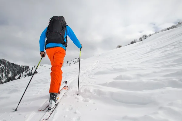 頂上に向かって登る山スキーを持つ男 — ストック写真