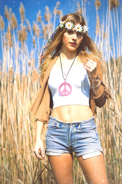 Hippie flicka med blommor krona om fred symbol — Stockfoto