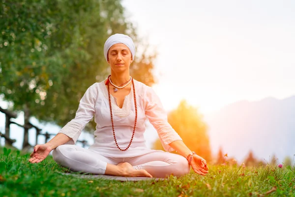 Frau mit weißem Kleid praktiziert Yoga — Stockfoto