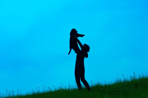 Silhouette of young woman with her dog — Stock Photo, Image