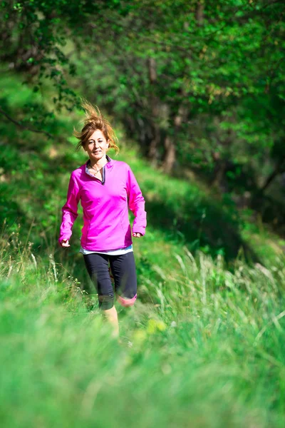 Chica con una sonrisa alegre corre en la naturaleza — Foto de Stock