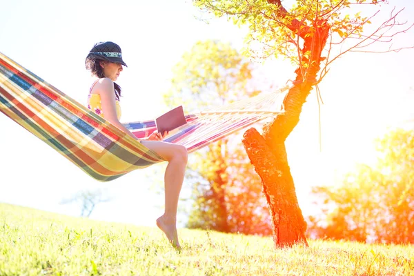 Woman on hammock reading a book in spring — Stock Photo, Image